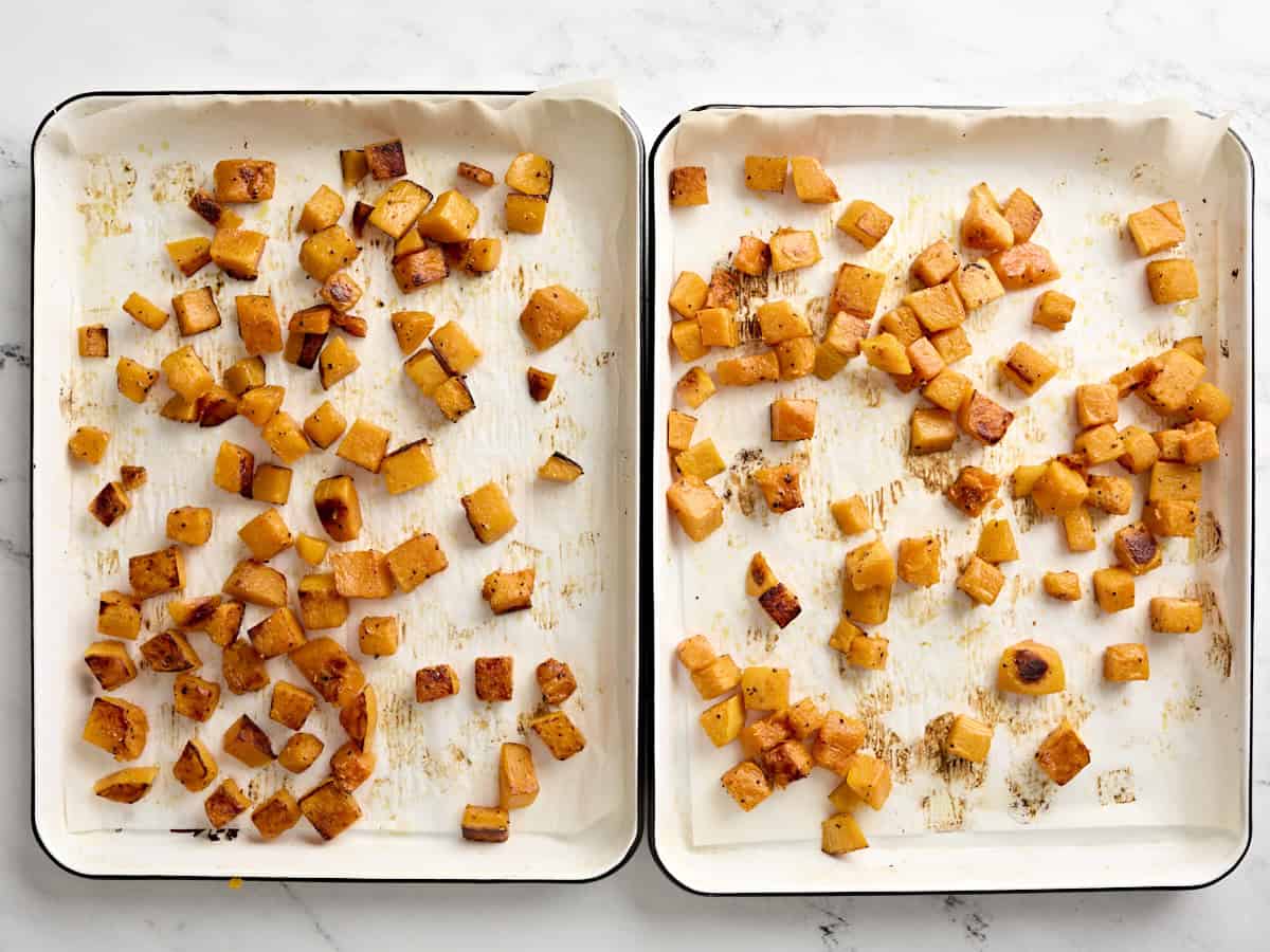 Roasted butternut squash on two parchment lined baking trays.