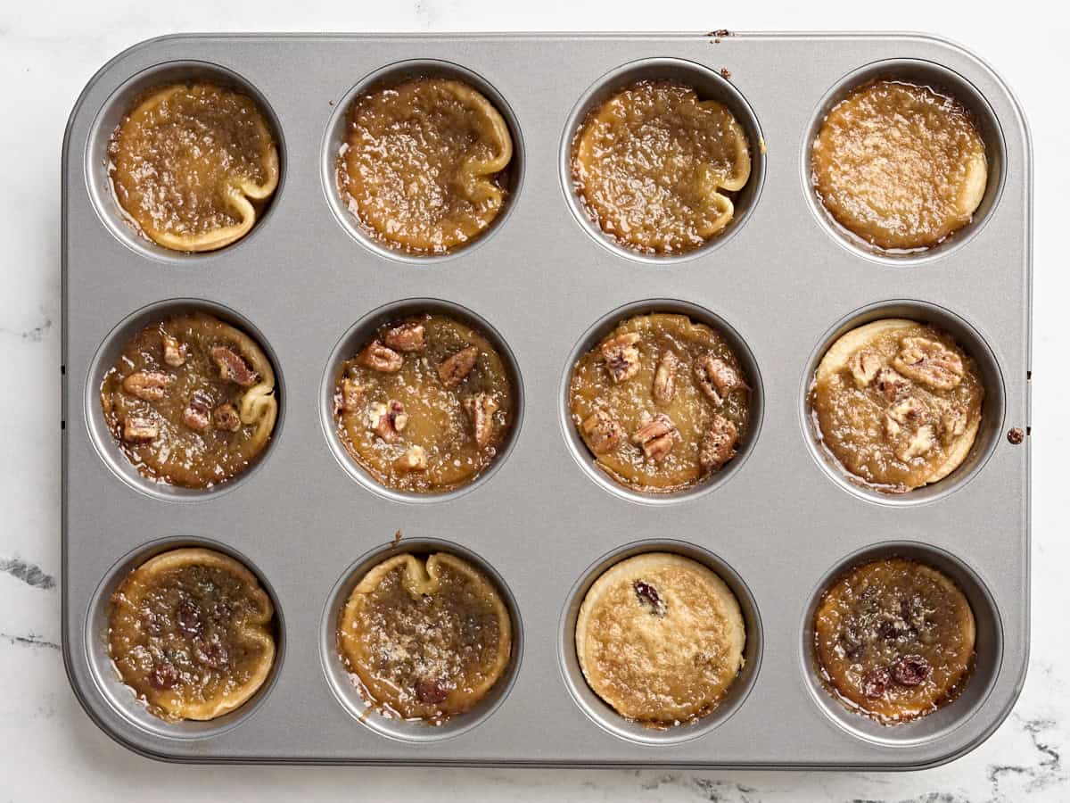 Freshly baking butter tarts in a cupcake tin.