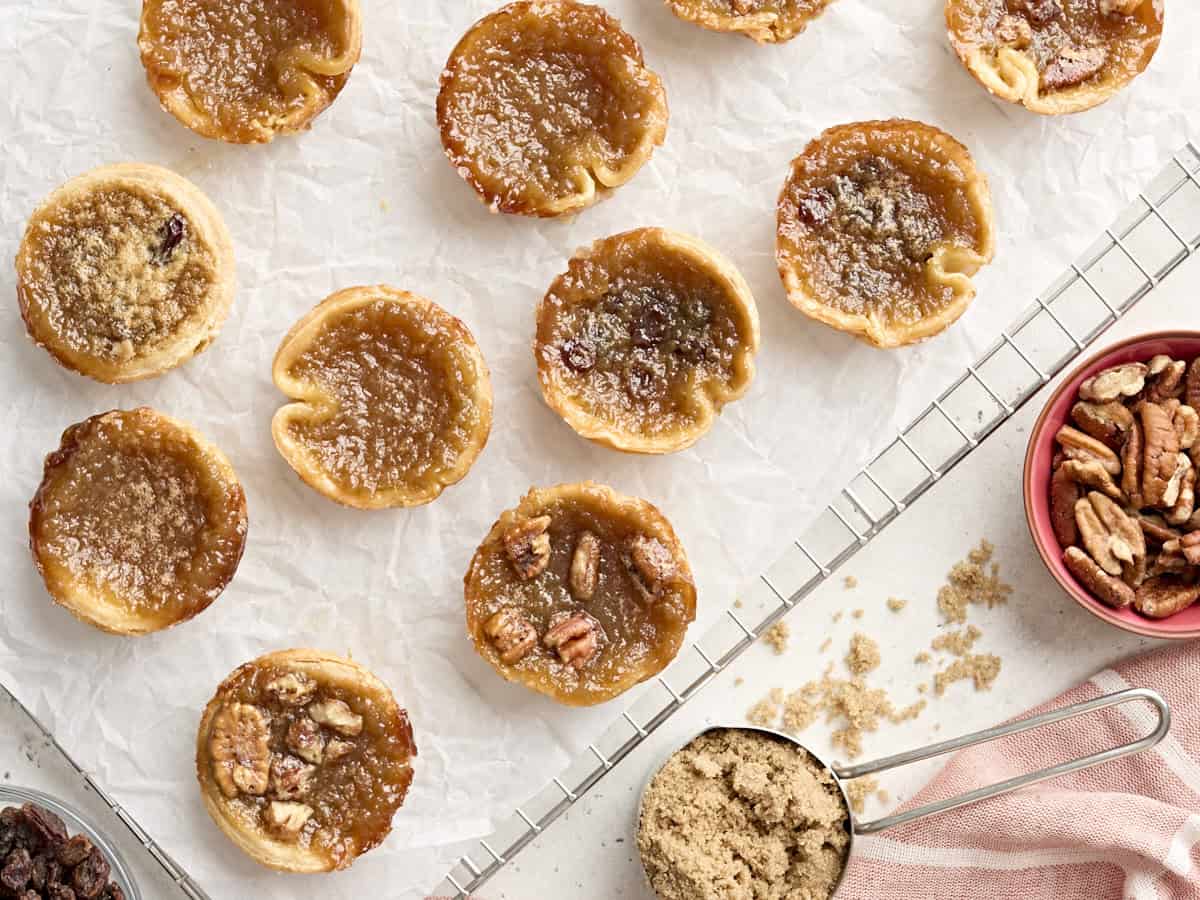 Overhead view of butter tarts on a parchment lined cooling wrack.