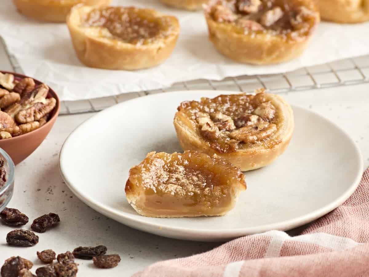 Side view of butter tarts on a plate.