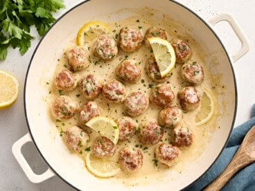 Overhead view of Chicken meatballs in a large skillet with a lemon cream sauce.