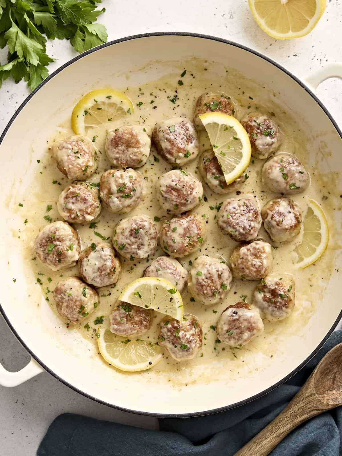 Overhead view of Chicken meatballs in a large skillet with cream sauce.