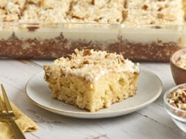 Side view of a fluffy cake with icing on a plate.