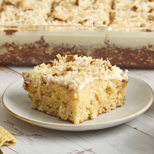 Side view of a fluffy cake with icing on a plate.