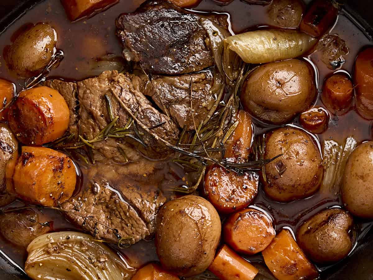 Close up of a pot roast and vegetables.