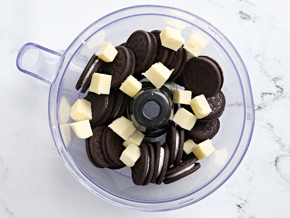 Oreos and cubed butter in a food processor.