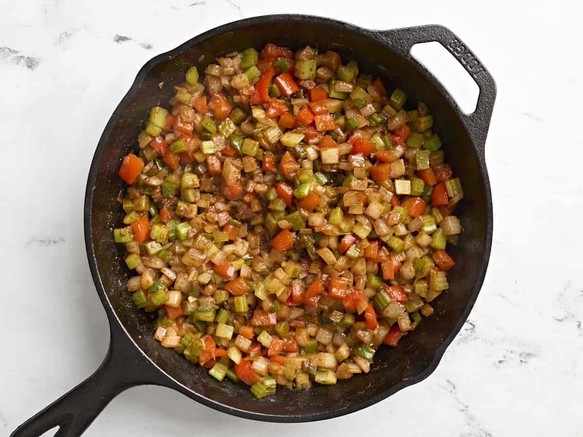 Mirepoix vegetables cooked down in a skillet for shakshuka.