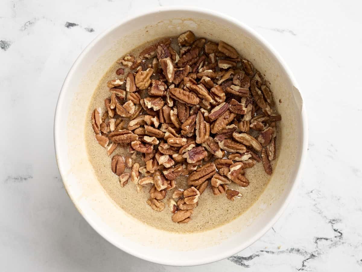 Pecans added to the filling for pecan pie in a mixing bowl.