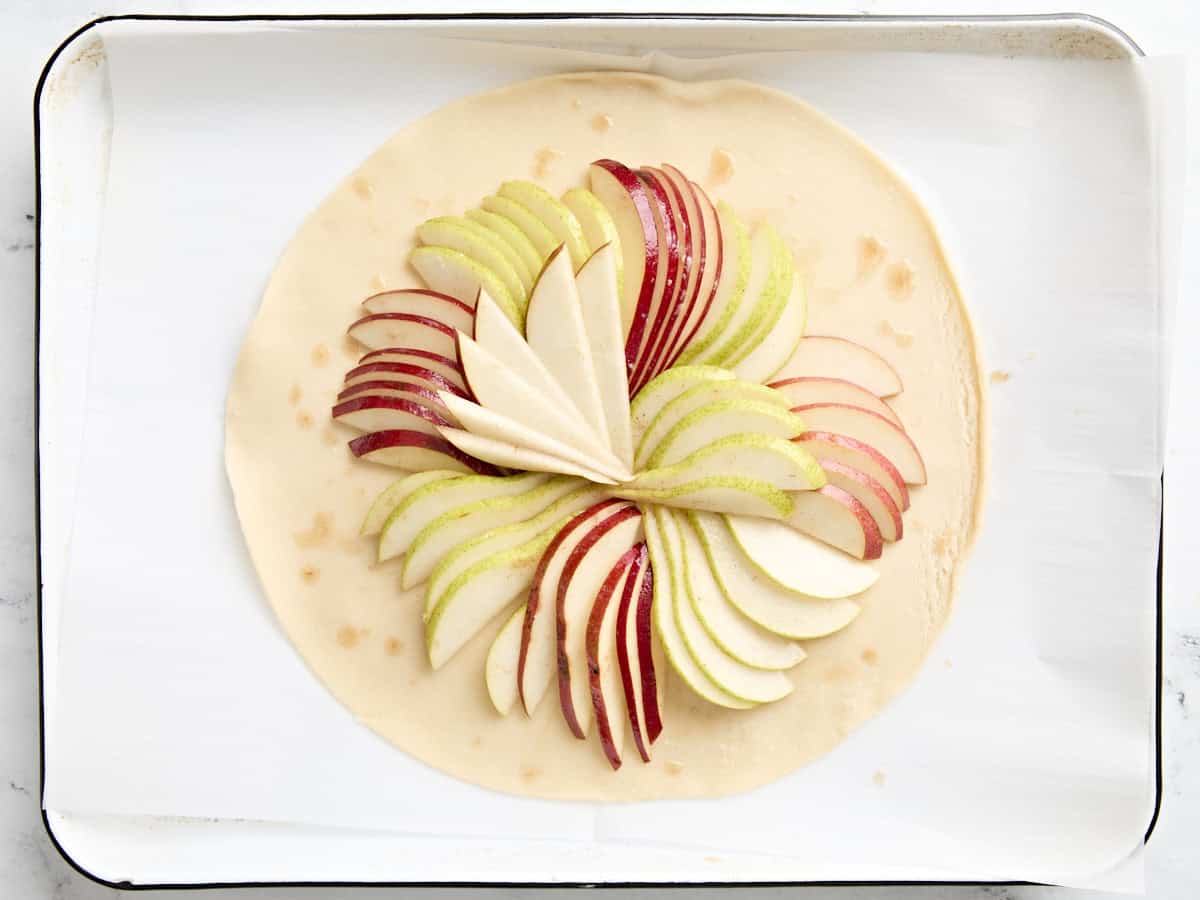 Sliced pears arranged in a fan style on an unbaked pre-made pie crust.