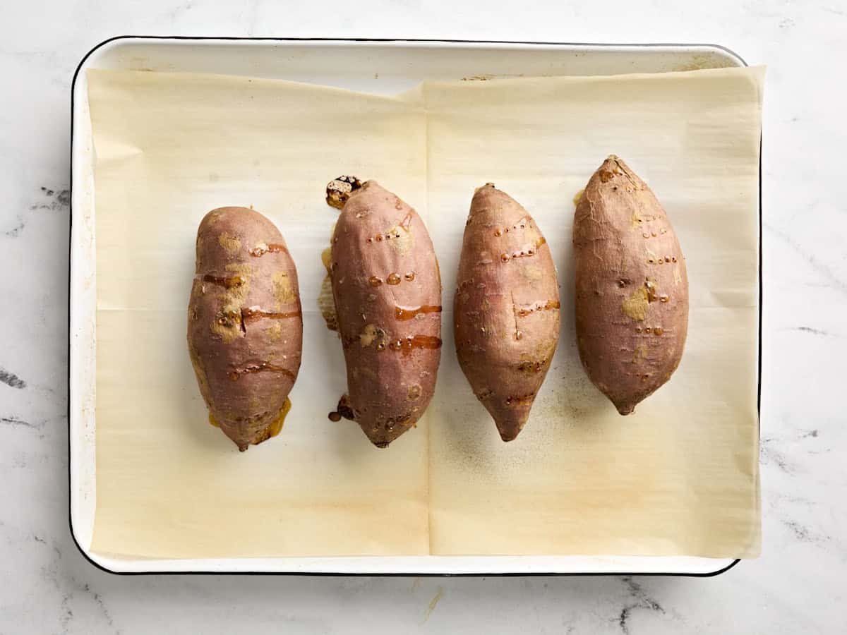 Baked sweet potatoes on a baking sheet.