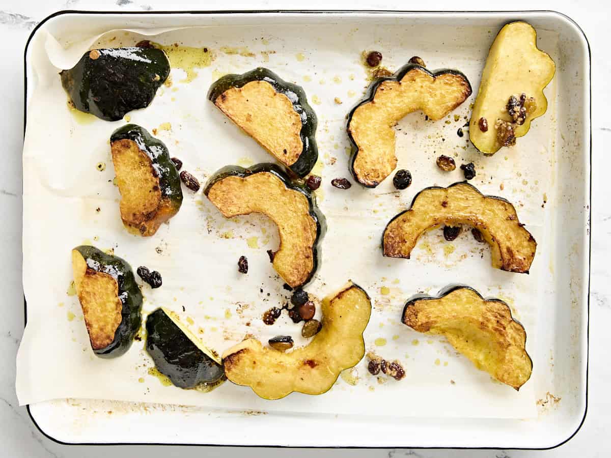 Roasted acorn squash slices on a baking sheet.