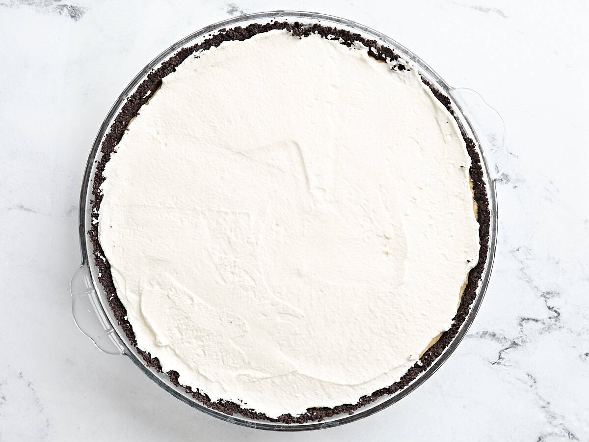 Overhead view of peanut butter pie topped with whipped cream.