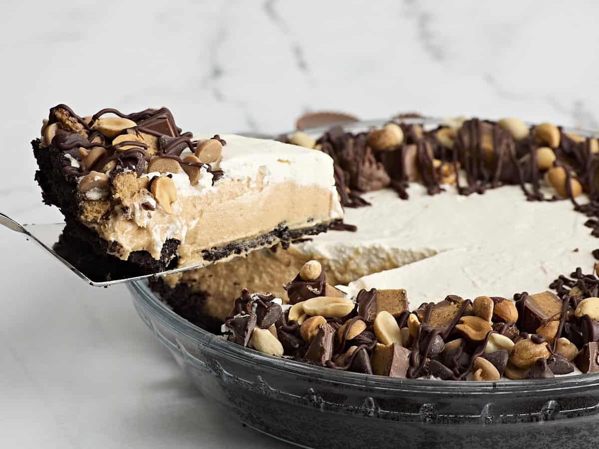 Side view of a piece of peanut butter pie being taken from a pie dish.