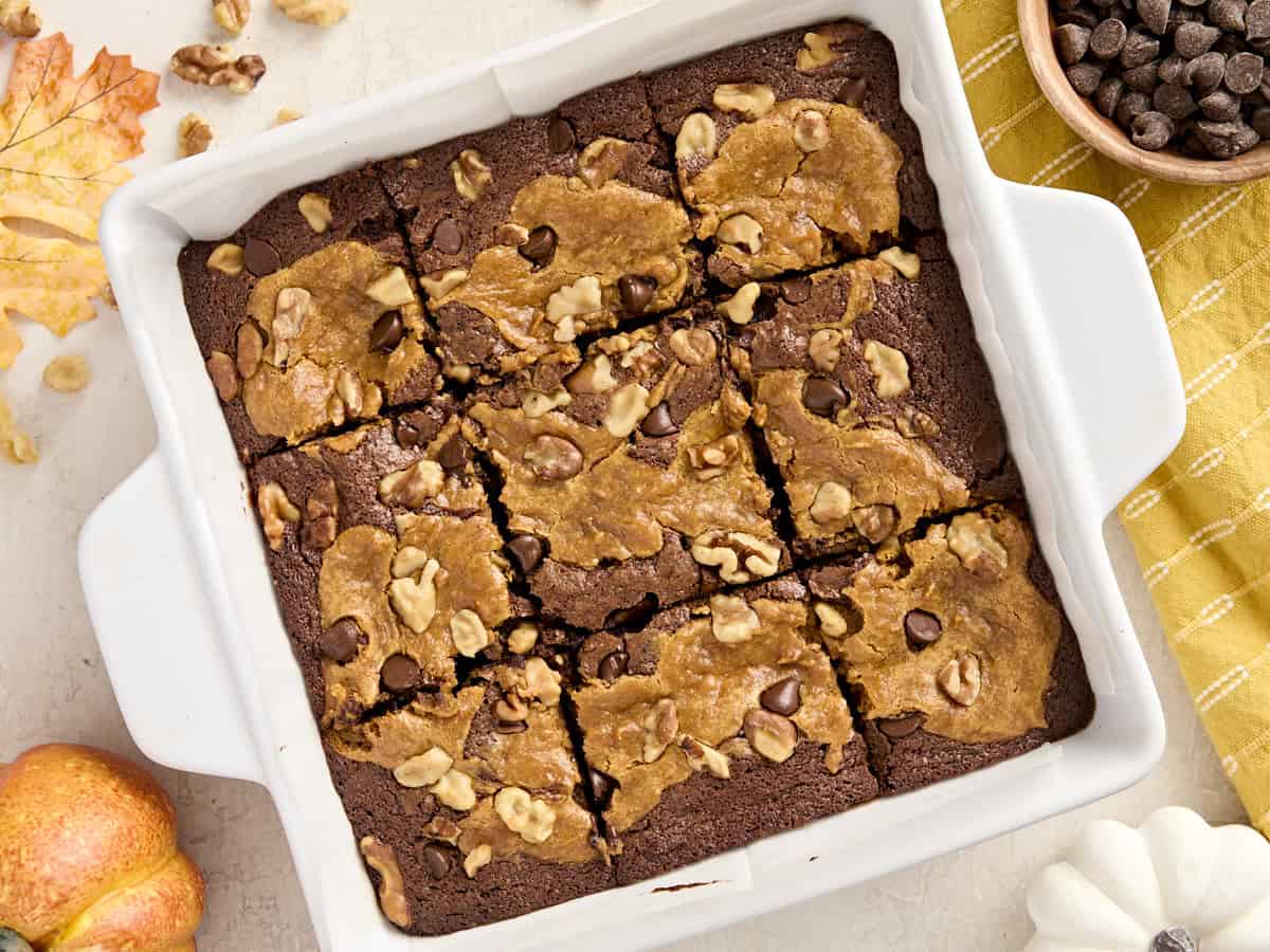 Overhead view of pumpkin brownies in a parchment lined baking dish.