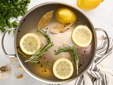 Overhead view of turkey breast brine in a large stainless steel pot.