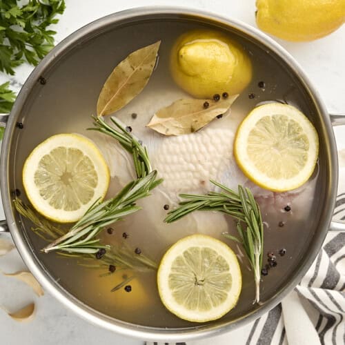 Overhead view of turkey breast brine in a large stainless steel pot.