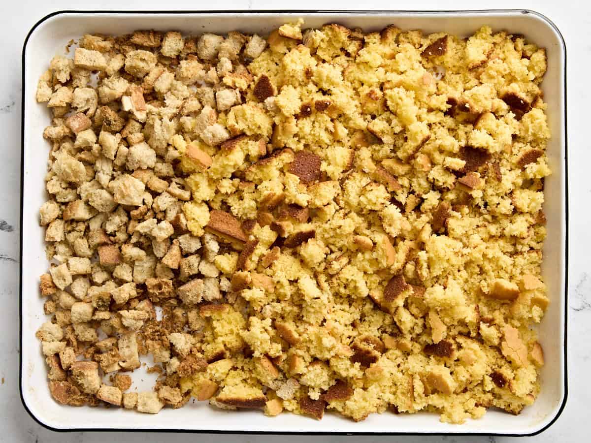 Cornbread and breadcrumbs on a large baking sheet.