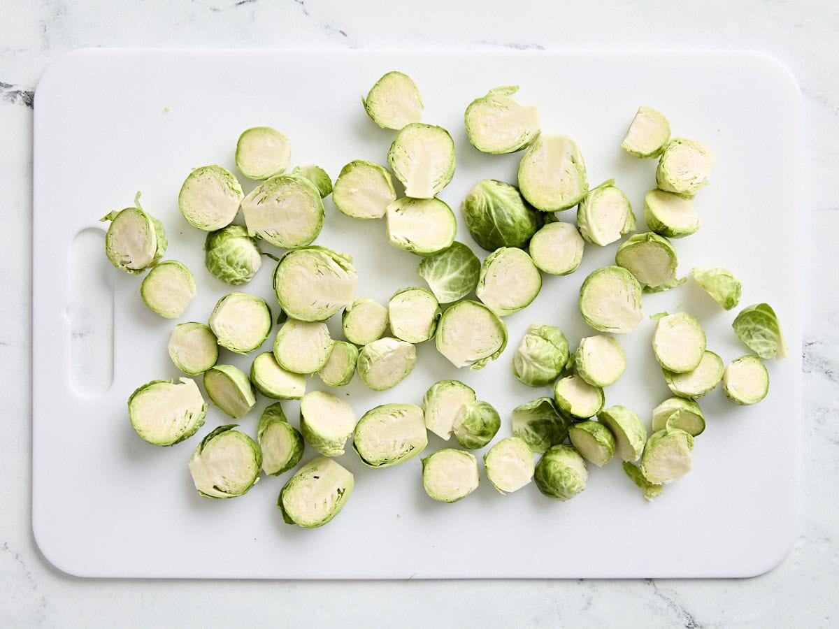 Sliced brussels sprouts on a chopping board.