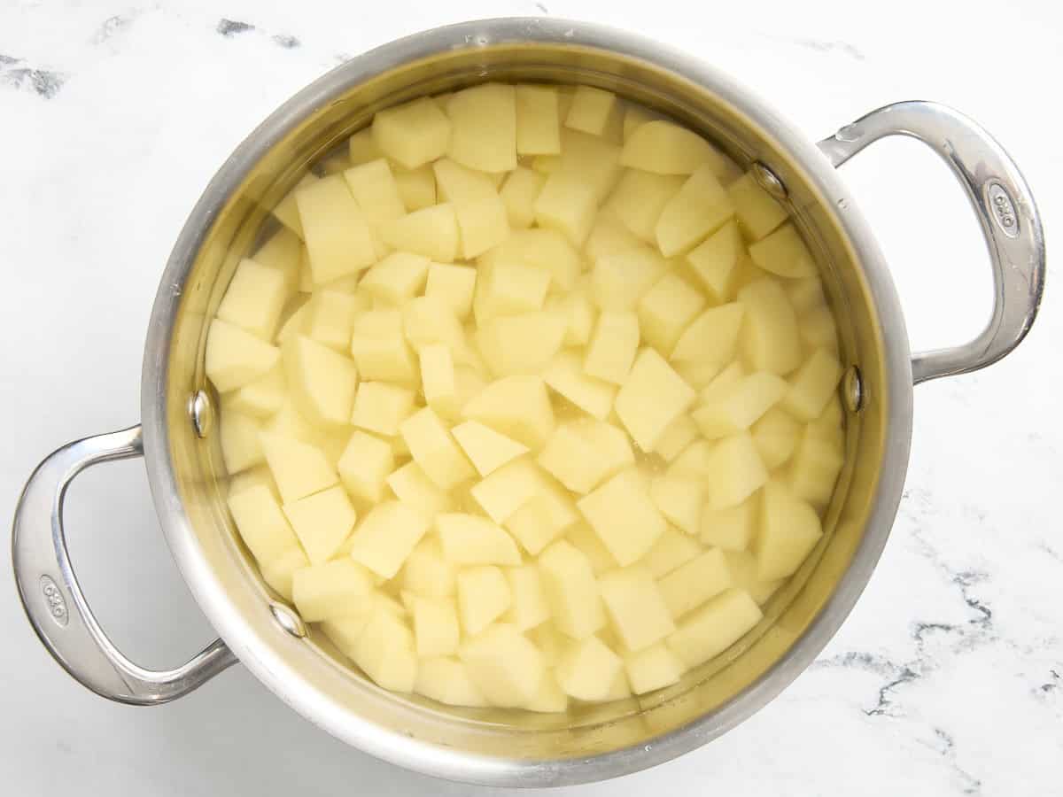 Diced potatoes in a pan of water.