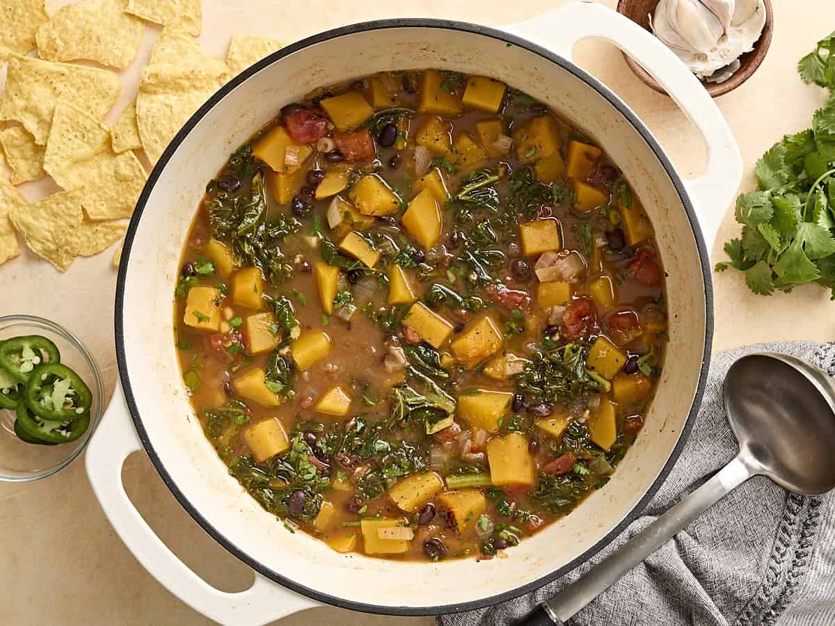 Overhead view of butternut squash and black bean soup in a dutch oven.