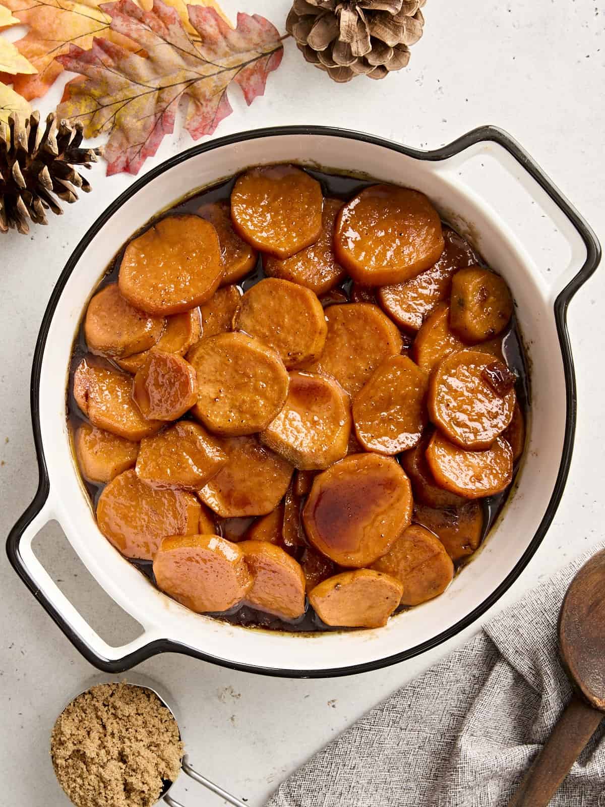 Overhead view of candied yams in a white serving dish.