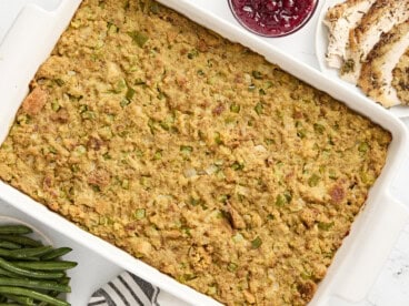 Overhead view of cornbread dressing in a large white baking dish.