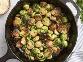 Overhead view of sauteed brussels sprouts in a cast iron skillet.