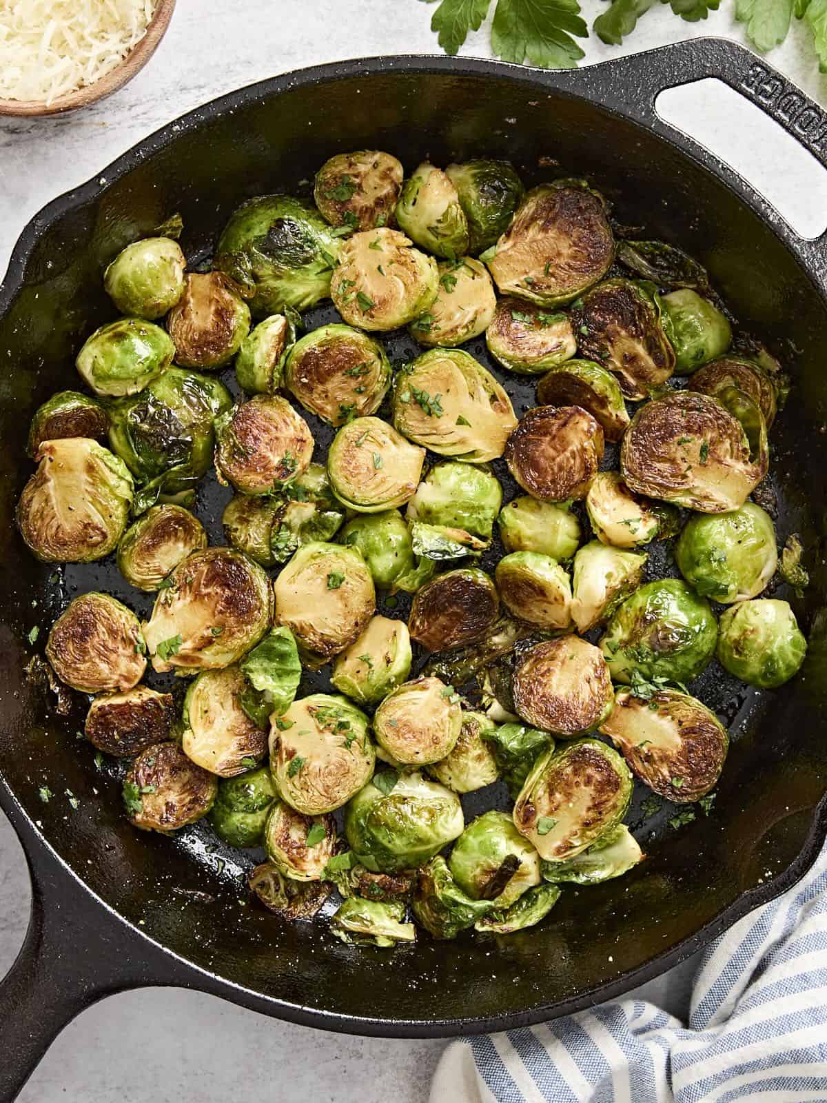 Overhead view of sauteed brussels sprouts in a cast iron skillet.