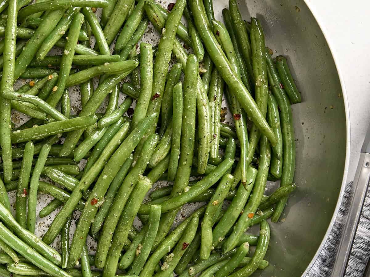 Overhead close up of sauteed green beans in a skillet.