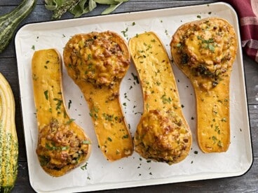 Overhead view of stuffed butternut squash on a baking tray.