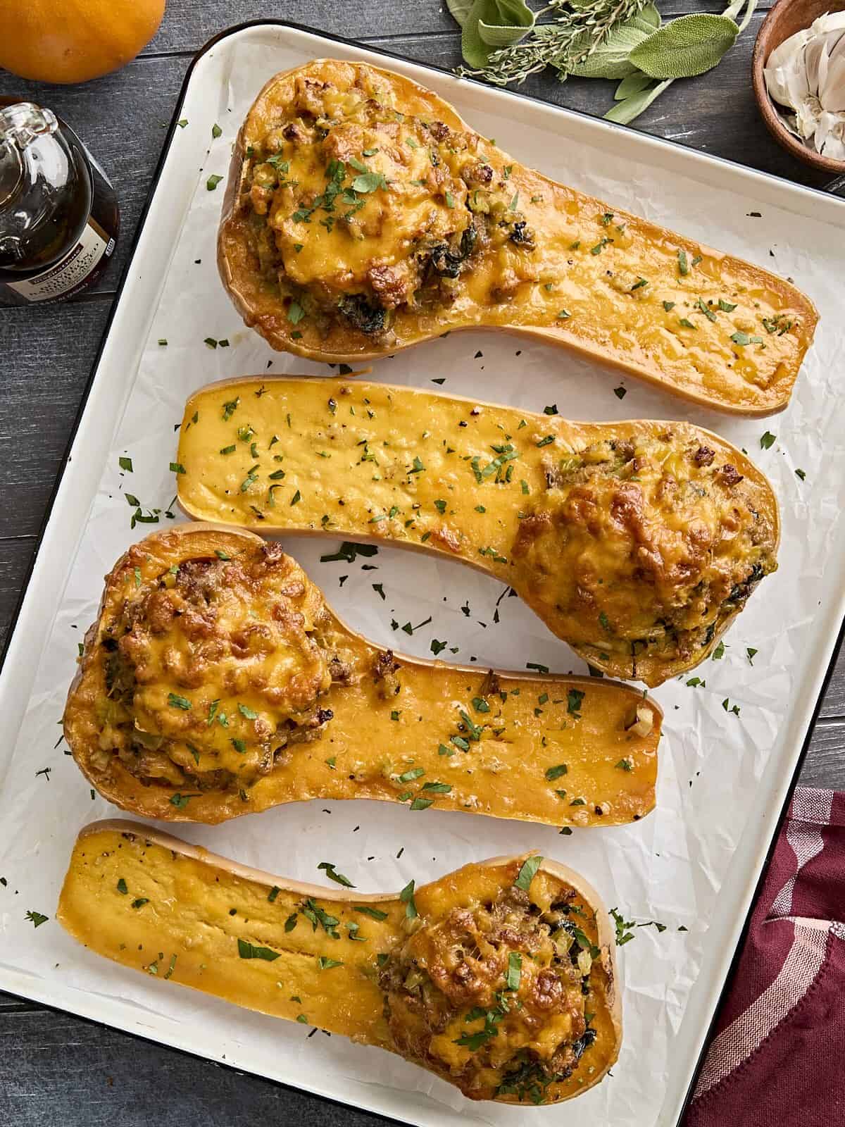 Overhead view of stuffed butternut squash on a parchment lined baking tray.