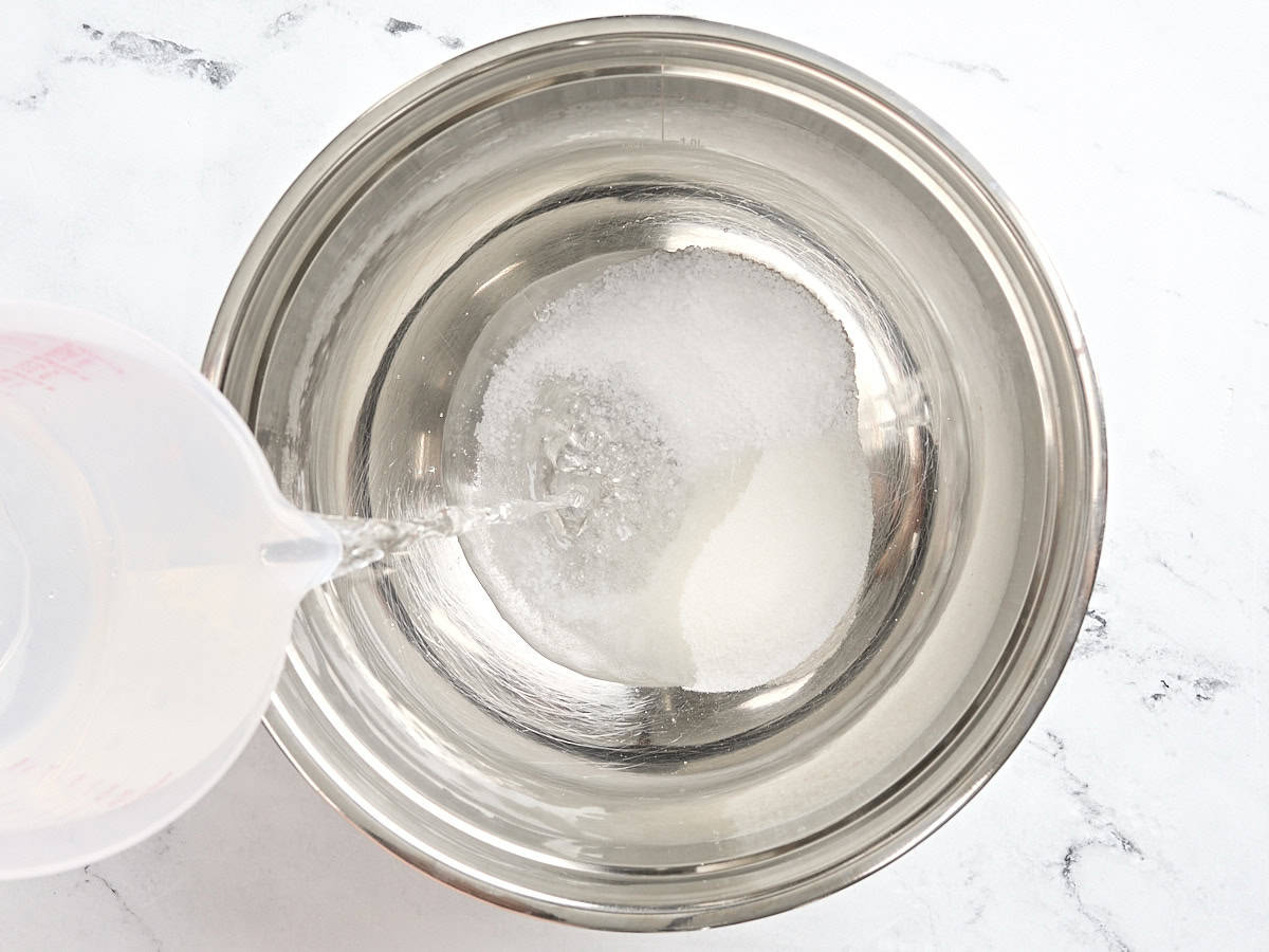 Baking being poured into a bowl with sugar and salt to make a brine for chicken breasts.