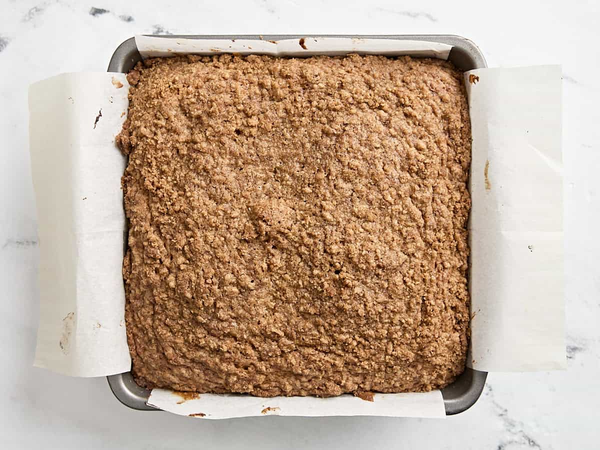 Freshly baked coffee cake in a parchment lined baking dish.