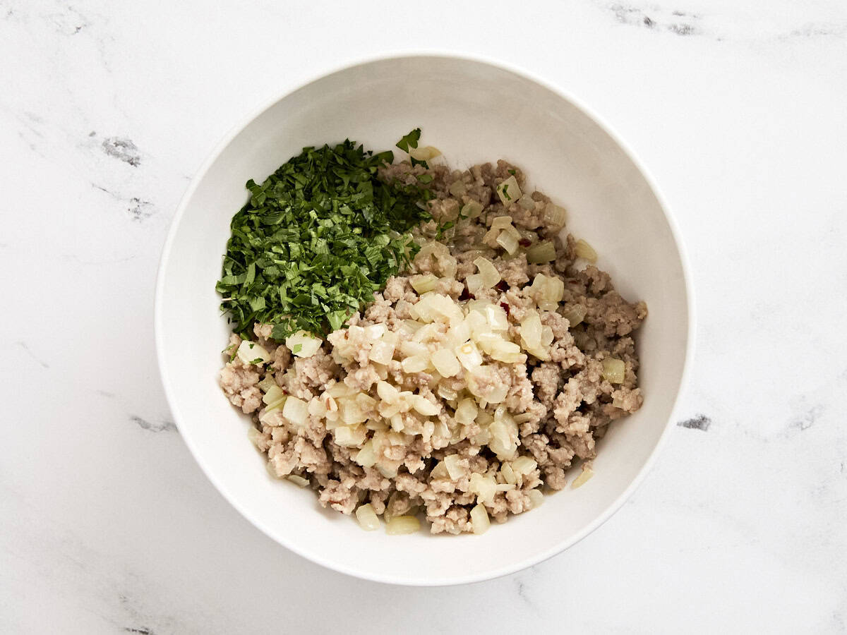 The sausage mixture for sausage and cheese hand pies in a mixing bowl.