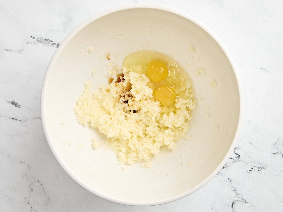 Eggs added to creamed butter and sugar mixture in a mixing bowl.