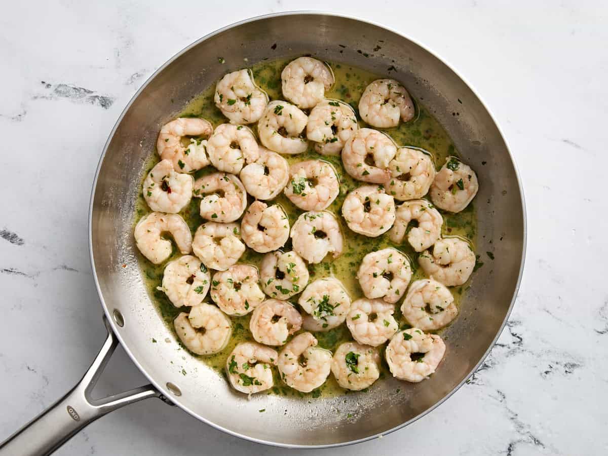 Overhead view of shrimp scampi in a skillet.