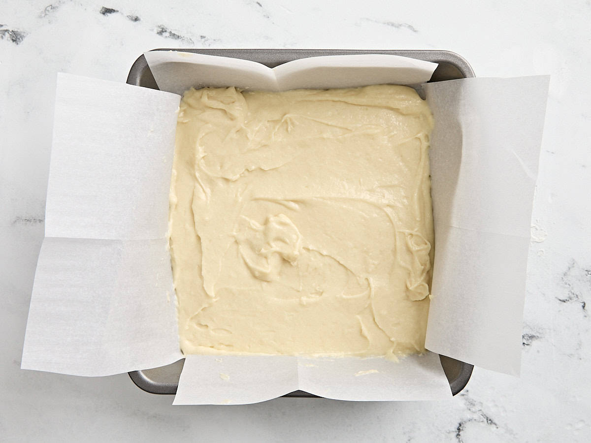 Coffee cake batter in a in a parchment lined baking dish.