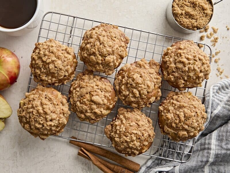 Overhead view of multiple apple cinnamon muffins on a wire cooling rack.