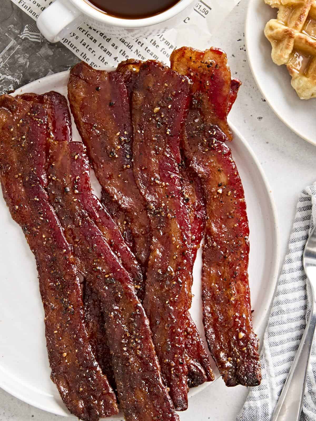 Overhead view of candied bacon on a plate.