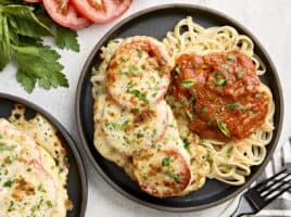 Overhead view of cauliflower parmesan on a plate with noodles and marinara sauce.