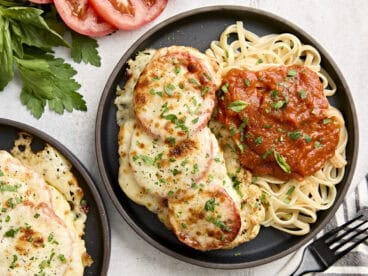 Overhead view of cauliflower parmesan on a plate with noodles and marinara sauce.