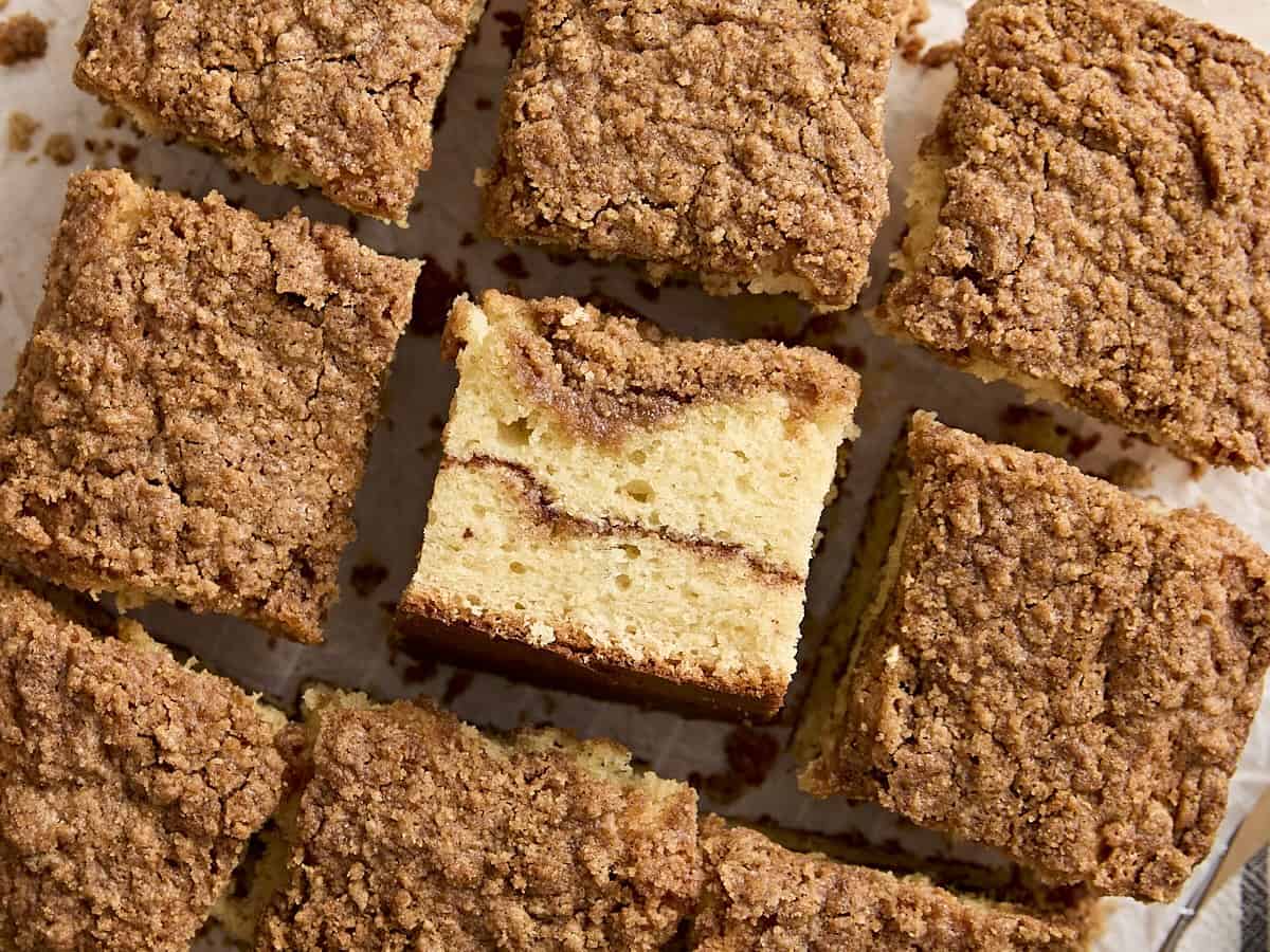 Overhead view of a coffee cake cut into slices, with one slice flipping on its side.