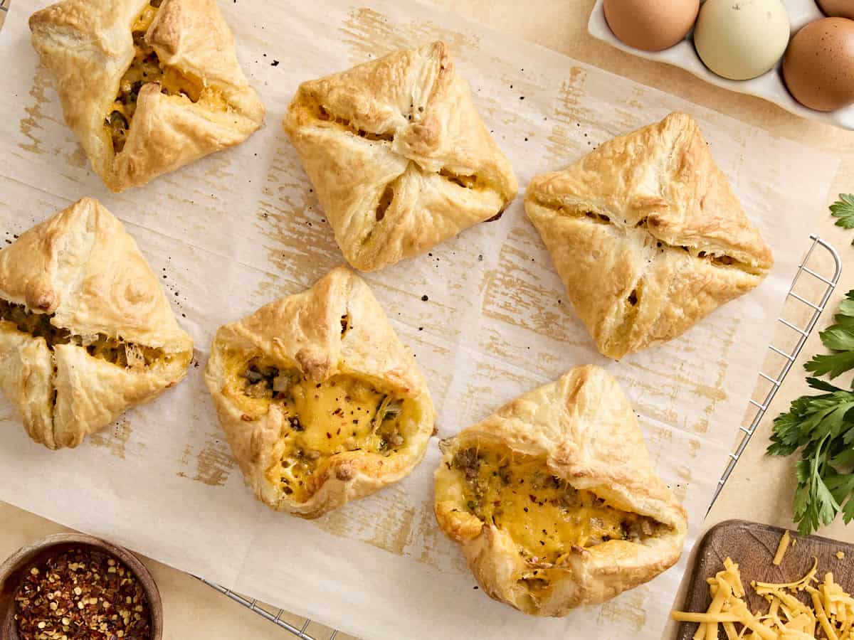 Overhead view of sausage and cheese hand pies on parchment paper.